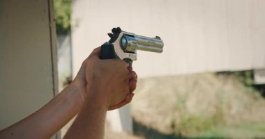 Atış talimi sırasında tabancayı nişan alan kişi..