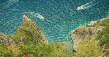 Yaz tatilleri boyunca Capri 'de engebeli uçurum oluşumlarında tekneler dolaşır..