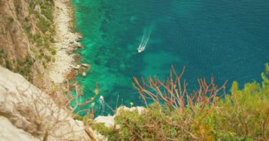 Tekneler, Capri Adası 'nın kayalık kayalıkları yakınlarındaki turkuaz deniz sularında yol alır..