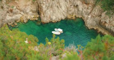 Capri 'nin tenha bir körfezinde, yaz mevsiminde zümrüt deniz suyuyla demirlemiş eğlence gemileri..