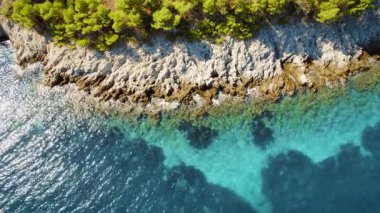 Yunanistan 'ın İyon kıyıları boyunca berrak suları ve yeşil çam ağaçları olan kayalık kıyı şeridi.