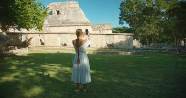 Antik Maya harabelerinde büyük basamaklı piramit yapısını fotoğraflayan kadın.