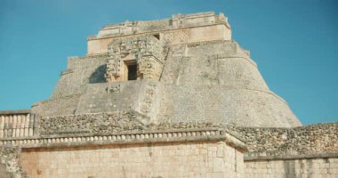 Maya antik piramit yapısı, bir seyahat keşfi sırasında mavi gökyüzü altında harabeler oluşturur..