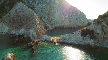 Kefalonia 'daki gözlerden uzak turkuaz bir koyda kayalık uçurumlar yükseliyor..