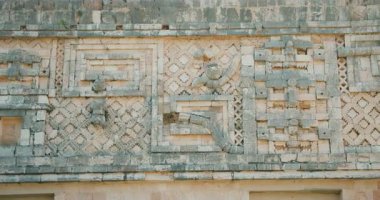 Meksika 'daki bir tapınağın taş cephesinde Maya oymaları ve desenleri var..