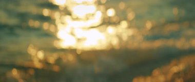 Güneş ışığı okyanus yüzeyine yansıyor ve sabah parlak bokeh etkisi yaratıyor..