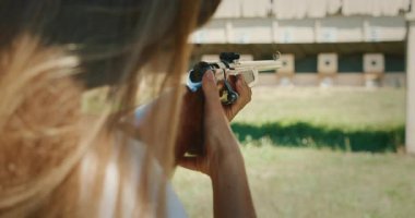 Atış poligonunda sürgülü tüfek kullanan bir kadın..