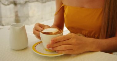 Yaz tatilinde güneşli Amalfi caddesindeki kafede kapuçino içen bir turist.