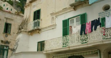 Atrani şehrinin dar sokaklarında balkonları ve çamaşır ipleri olan eski binalar..