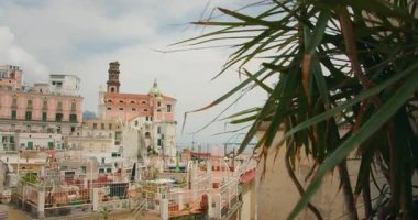 Kiliseli Atrani kasabası ve çatıdan bakan bitkileri olan binalar..