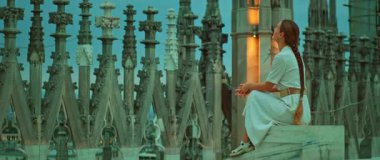 Duomo Milan Katedrali 'nin çatısında oturan kadın, alacakaranlıktaki Gotik kulelere hayran..