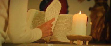 Kilisenin içinde dua eden bir anda Almanca İncil sayfasını mum ışığında çevirerek..