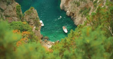 Yaz aylarında Capri, İtalya 'da kayalıklarla çevrili dar zümrüt koyuna demirlemiş tekneler..