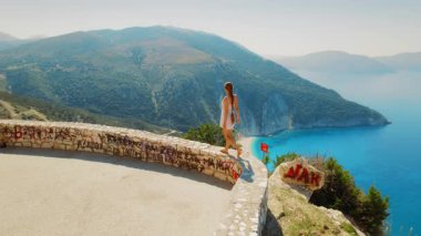 Yazın Kefalonia adasındaki Myrtos Sahili 'nin yukarısında yürüyen bir kadın..