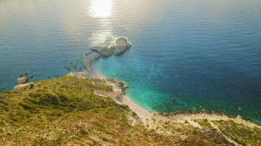 Turkuaz deniz ve Sefalonya 'daki kayalık çıkıntılı uzak kumsal manzarası..