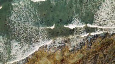 Yukardan görülen Yucatan kıyısındaki resif oluşumlarını aşan deniz dalgaları.