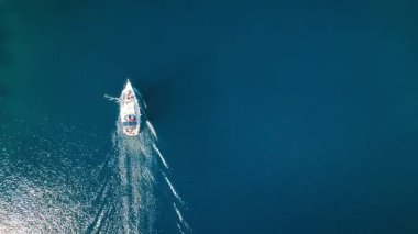 Yunanistan 'ın Kefalonya kıyılarında berrak mavi sularda yüzen bir tekne..