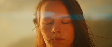 Açık hava aydınlatmasında gözleri kapalı bir kadının yakın çekimi.