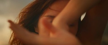 Gün batımında açık havada dans ederken ellerin ve yüzün bulanık hareketi..