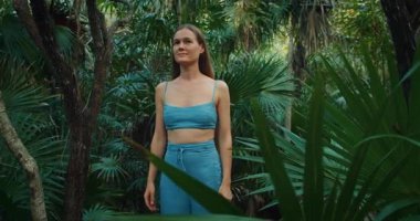 Yucatan Yarımadası 'nda palmiye ağaçları olan vahşi tropikal ormanı seyreden bir kadın..