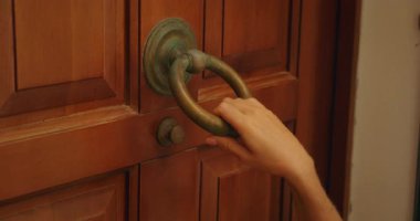 Kırsal ahşap kapıyı çalan antika metal yüzüklü bir kadın..