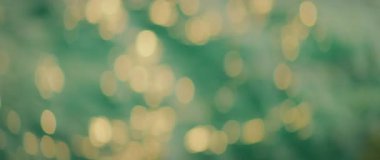 Odaklanamayan altın güneş ışığı gün batımında yeşil deniz suyunu yansıtıyor..