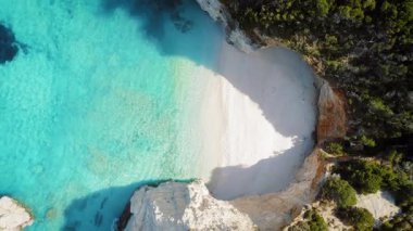 Etrafı kayalık kayalıklarla çevrili küçük, tenha, beyaz çakıl taşı plajı..