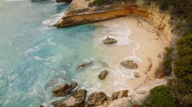 Yaz seyahati sırasında Kefalonia 'da ıssız bir koyda kayaların üzerinde duran bir kadın..