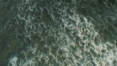 Okyanus yüzeyindeki köpüklü dalgalar koyu kıvrımlar gösteriyor..