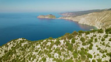 Kefalonia kıyı şeridi ve körfezi açık mavi gökyüzünün altında ufka doğru uzanıyor..