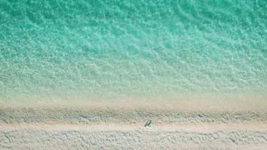 Turkuaz deniz ve yumuşak desenli beyaz çakıl taşı plajlı kıyı şeridi..