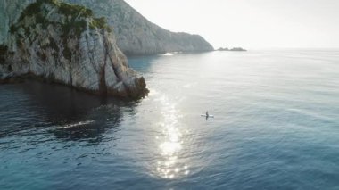 Yunanistan 'da sakin bir sabah ışığı altında kayalıkların yanında süzülüyor.