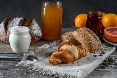 İskandinav ekmeği kruvasan, susamlı hamur işleri ev yapımı yoğurt balı ve marmelat portakalı greyfurt.