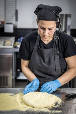 Şef mutfakta hamur işi yapıyor.