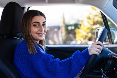 Araba süren genç bir kadın.