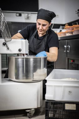 Genç bir aşçı mutfakta yemek hazırlıyor..