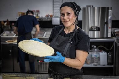 Restoranda yemek pişirmeye hazırlanan genç bir kadın.
