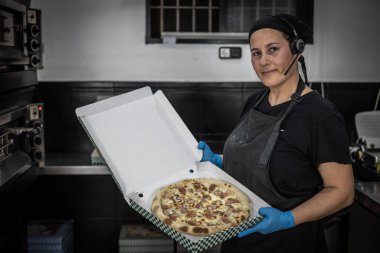 Mutfakta bir tepsi pizzayla şef
