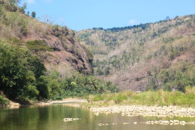 Bantul 'daki Sriharjo köyündeki tepeler ve nehirler. Mavi gökyüzü ile yeşil tepeler
