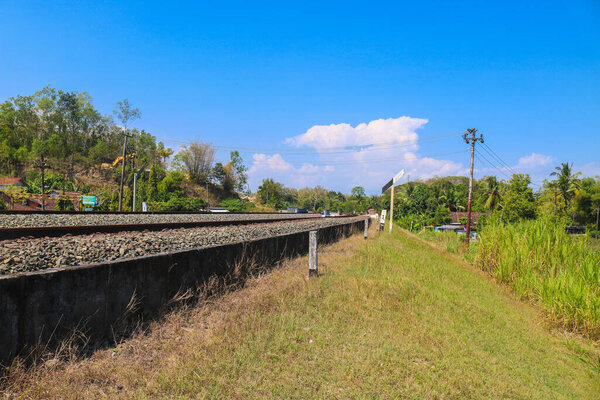 Трасса с видом на холмы и кукурузные и рисовые поля. Красивые горы ландшафтный железнодорожный путь в Индонезии.