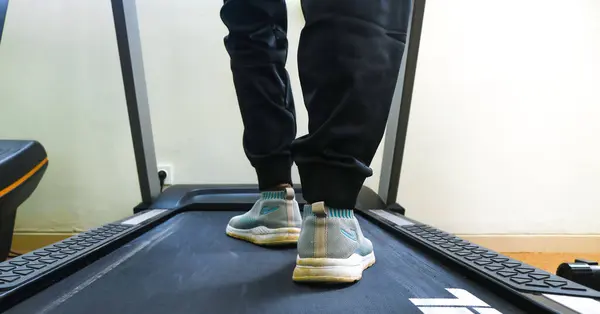 Bir fitness kulübünde koşu bandında koşan bir kadının bacaklarını kapatın. Koşu bandında koşan bir kadın, egzersiz konsepti, kardiyo egzersizi, egzersiz, kilo verme..