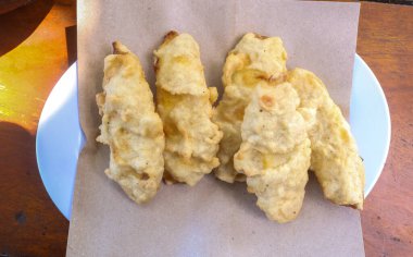 Beyaz bir tabakta servis edilen gevrek ve tatlı muzlar. Geleneksel Asya yemekleri, Endonezya sokak yemekleri