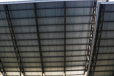 Çelik yapısı olan gümüş kıvrımlı teneke çatının alt manzarası. Metal çatı. Demir çadır. Spor stadyumunun çatısı