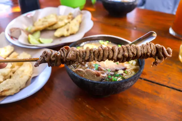 Stock image Close up and selective focus of intestine satay and chicken intestine satay with chicken soup background. traditional Indonesian street food