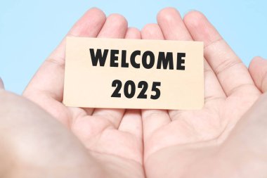 Elinde bir notla 2025 'e hoş geldin. Tipografik 2025 ile yeni yıl konsepti. 2025 yılını kutlamak için motive edici sözler.