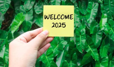Elimde bir not var. 2025 'e hoş geldiniz. Tipografik 2025 ile yeni yıl konsepti. 2025 yılını kutlamak için motive edici sözler.
