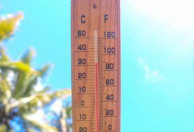 Celsius ve Fahrenheit termometresi Asya 'da gün ortasında artı 30 derecenin gökyüzü arka planında olduğunu gösteriyor. Termometre, yazın 30 derecenin üzerinde sıcaklık gösteriyor.