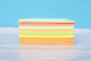 Mavi zemin üzerine boş yapışkan not kağıdı yığın. Renkli yapışkan notlar yığını