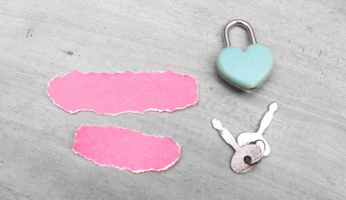 Yırtık kağıt ve mavi kilit gri masada. Yazmak için boşluk. Yırtık kağıt kavramı üzerine harf