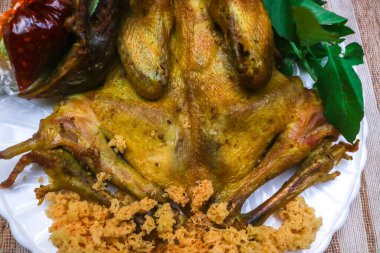 Endonezya kreması serpiştirilmiş kızarmış tavuk. Yanında karides ezmesi biber sosu ve taze yeşil sebzelerle servis edilir.